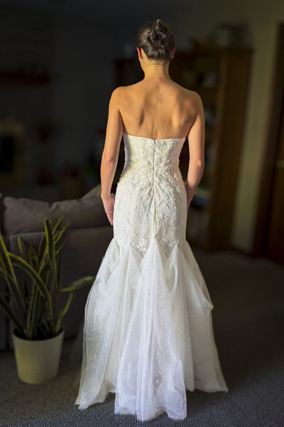 Back view of a strapless lace wedding dress with a flared skirt